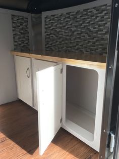 the inside of a kitchen cabinet with its doors open