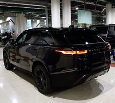 an suv is parked in a showroom with other cars