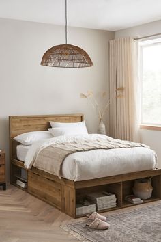 a bed sitting in a bedroom on top of a wooden floor next to a window