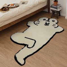 a cat rug on the floor next to a bed