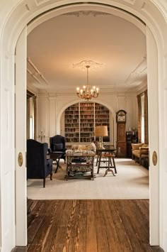 an archway leads into a living room with wood floors