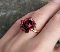 a woman's hand with a rose ring on it