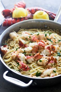 a pan filled with shrimp and pasta on top of a table