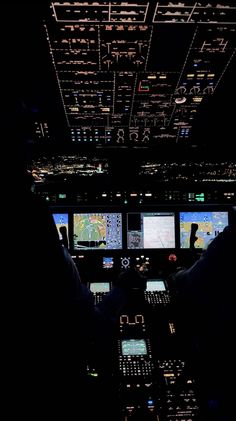 an airplane cockpit at night with multiple monitors