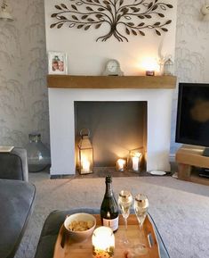 a living room filled with furniture and a fire place in front of a tv mounted on a wall