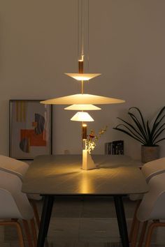 a dining room table with four chairs and a lamp