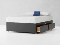 a bed with two drawers underneath it and a pillow on top of the headboard