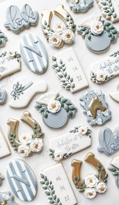 decorated cookies are arranged on a table with white and blue decorations in the shape of letters