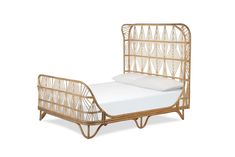 the bamboo bed frame is made with white sheets and has an intricate design on it