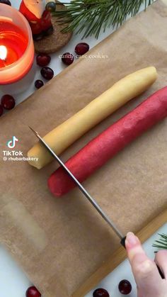 a person is using a knife to cut an apple on a piece of parchment paper