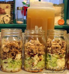 four jars filled with food sitting on top of a counter