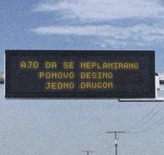 a sign that is on the side of a road in front of some power lines