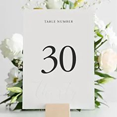 a table number is placed next to a bouquet of flowers