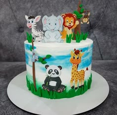 a birthday cake decorated with animals and giraffes