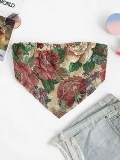 the floral dog bandana is laying on top of denim shorts and sunglasses next to it