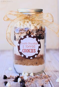 a glass jar filled with cookies on top of a table