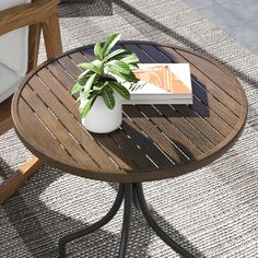 a table with a book on it and a potted plant sitting on top of it