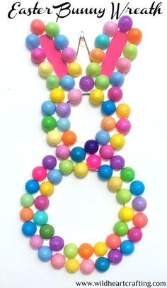 an easter bunny necklace made out of colorful beads and plastic eggs on a white background