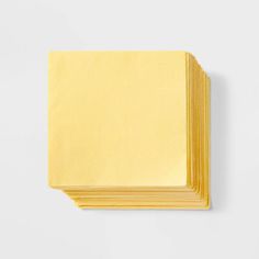 five yellow napkins stacked on top of each other in front of a white background