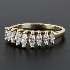 a yellow gold ring with five pear shaped diamonds