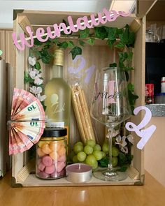 a wooden box filled with lots of food and drinks next to a bottle of wine