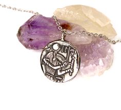 This beautiful pendant depicts the god Thoth on the front, and lotus flowers on the reverse.  Thoth was the god of the moon, sacred texts, mathematics, the sciences, magic, messenger and recorder of the deities, master of knowledge, and patron of scribes. In ancient Egypt, the lotus represented rebirth. This meaning was inspired by the nature of the lotus's petals that spread above water upon sensing sunlight and closed during the night so as for the flower to fall back under water. Sprouting from the bottom of the river, the lotus flower generally opens up its petals against the surface of water. This pendant is about 1 inch in diameter, made in bronze, and oxidized for contrast. This item Ships For FREE Please follow us on facebook at: www.facebook.com/artemistx Or find us on instagram: Handmade Silver Coin Necklace With Symbolic Style, Silver Necklace With Round Pendant In Vintage Style, Spiritual Silver Coin Necklace With Large Pendant, Spiritual Silver Coin Necklace Gift, Silver Necklace With Vintage Round Pendant, Spiritual Silver Coin Necklace With Round Pendant, Handmade Symbolic Coin Necklace, Silver Ancient Style Jewelry For Gift, Symbolic Silver Coin Necklace As Gift