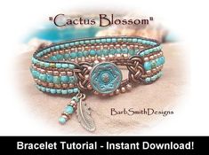 a bracelet with turquoise beads and an arrow charm on it, sitting in the sand