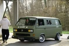 a green van parked under a bridge next to a man