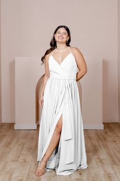 a woman in a white dress standing on a wooden floor