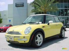 a small yellow car parked in front of a building