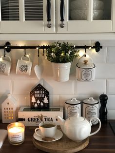 the kitchen counter is decorated with teacups and candles