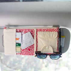 a pair of sunglasses hanging from the side of a car window with some items in it