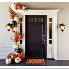 the front door is decorated with pumpkins and other decorations