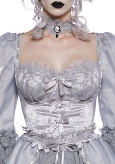 This ghostly French queen costume includes a mini dress that has a mixed sateen and lace construction, floral lace detailing, an underwire bust with a lace overlay, puffy sleeves with ribbon ties, an organza overlay with ripped details, decorative bows on the front, a layered flare skirt with tulle underneath, and a back zip closure. Includes wig with floral appliques and a lace choker with a skeleton woman cameo charm and ribbon tie closure. Halloween Lace Corset Costume Dress, Halloween Lace Corset Dress With Corset Back, Halloween Party Lace Corset Dress, Halloween Lace Corset Dress For Party, Halloween Elegant Lace Corset, Elegant Halloween Costume Corset, Halloween Underbust Lace Corset, Halloween Lace Underbust Corset, Elegant Lace Corset For Halloween