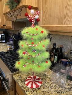 a christmas tree decorated with candy canes and candies on top of a kitchen counter