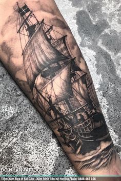 a man's arm with a ship tattoo on it