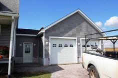 a white truck parked in front of a gray house