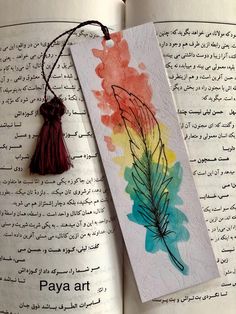 an open book with a tassel hanging from it's cover and the words paya art written in arabic