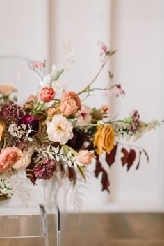 a vase filled with lots of flowers on top of a table