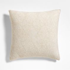 a white pillow with a diamond pattern on the front and back, against a white background