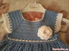 a blue crocheted dress with a flower on it