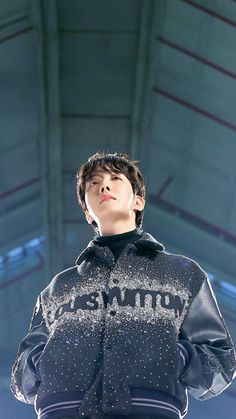 a young man standing on top of a stage wearing a black and white jacket with sequins