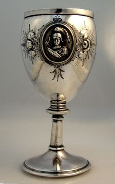 an ornate silver goblet with a portrait on it