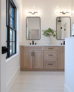 a bathroom with double sinks and two mirrors on the wall next to eachother