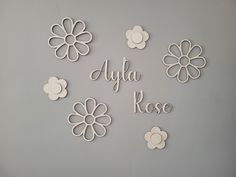 the wall is decorated with white flowers and words that spell out,'alya rose '