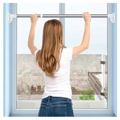 a woman standing in front of a window with her arms up and hands on the bars