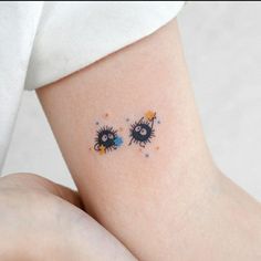 two black and yellow eyes on the side of a woman's arm