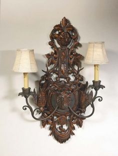 an ornate wooden wall light with two lamps