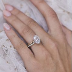 a close up of a person's hand with a diamond ring on their finger