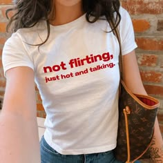 "Not Flirting Just Hot And Talking" Graphic Slogan Printed On Aesthetic Retro Vintage 90s Y2k Baby Tee Shirt with our own unique font.  🎨 Available in White, Light Pink, Light Blue, Navy, Black. If you need a different color, please let us know! (Ash, Red, Sport Grey & Green)  🎁 Our baby tees are perfect gift for her or him offering timeless fashion and versatility that anyone will cherish. Baby tees, popular in the '90s, have short sleeves and a slightly cropped body, giving a flattering femi Words On Shirts Aesthetic, Print T-shirts, Let The Light In, Y2k Style Crew Neck Shirt With Text Print, 90s Style Fitted Shirt With Letter Print, Fitted Slogan Shirt With Crew Neck, 90s Fitted Shirt With Letter Print, Fitted Y2k Crew Neck Shirt, Y2k Crew Neck Pre-shrunk Shirt